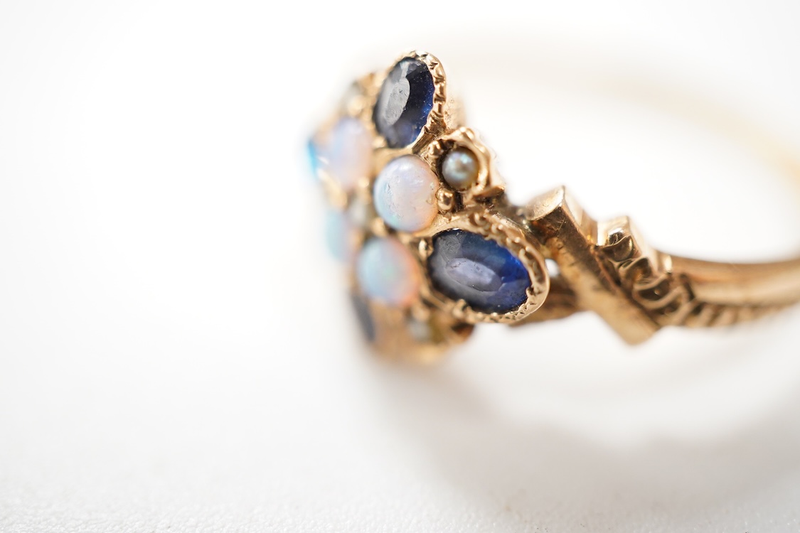 A late Victorian yellow metal, sapphire, opal and seed pearl cluster set dress ring, (one stone a paste replacement), size N, gross weight 2.2 grams.